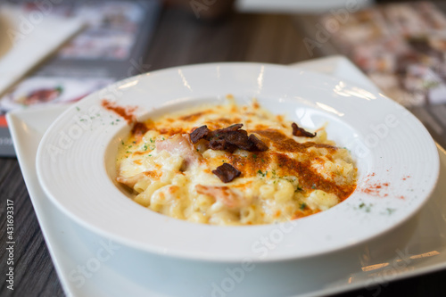 Angle top view of macaroni cheese with bacon paprika chilli is topping.