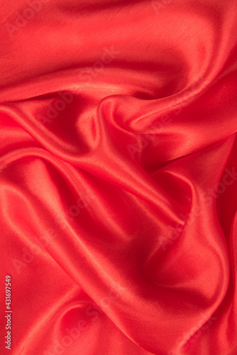 Abstract red silk fabric texture background. Cloth soft wave. Creases of satin