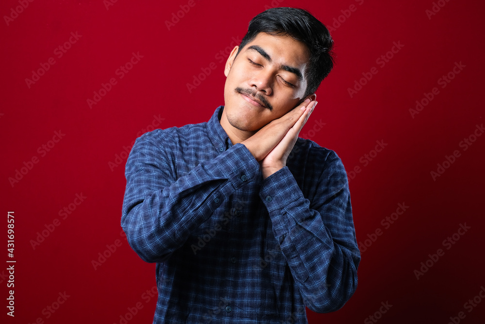 Asian handsome man wearing shirt sleeping tired dreaming and posing with hands together while smiling with closed eyes