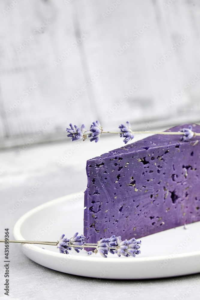 Piece of lavender cheese with dry basil and lavender flowers Piece of lavender cheese with dry basil and lavender flowers