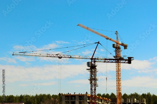 Construction cranes on blue sky background