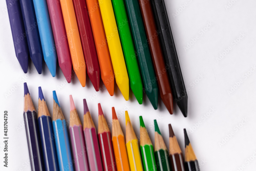 High angle close up shot of crayons and pencil colors shot on white surface -Art and Education concept. High angle close up shot of crayons and pencil colors shot on white surface -Art and Education concept.