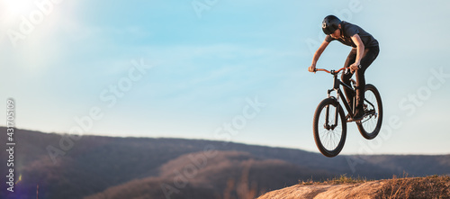Fototapeta Naklejka Na Ścianę i Meble -  Young man flying through the air on a mountain bike