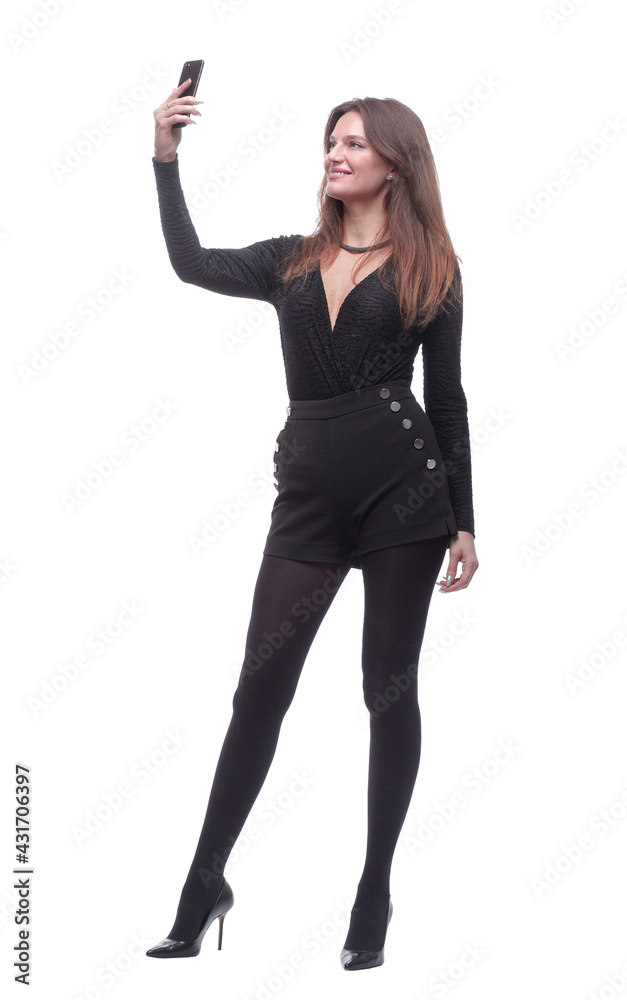 in full growth. smiling young woman taking a selfie.