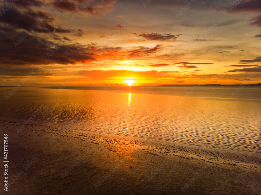 Obraz premium Beautiful sunset colors over the coastline of Allerdale district in Cumbria, UK. Sun setting over the shore of Allonby bay on autumn.