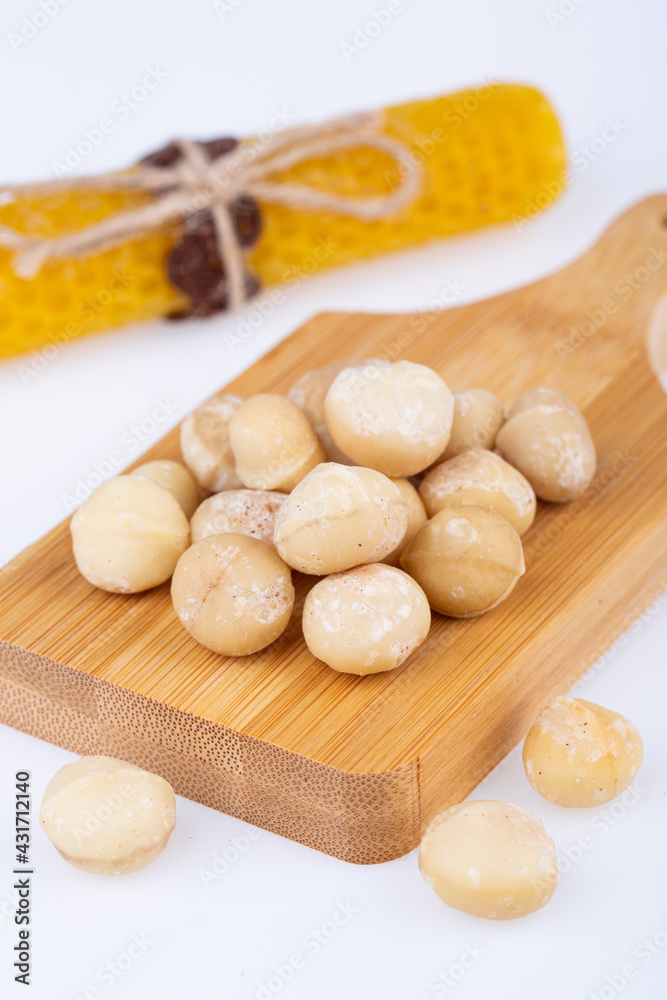 macadamia nuts, large, solid, cleaned, on a wooden board, on a white background macadamia nuts, large, solid, cleaned, on a wooden board, on a white background