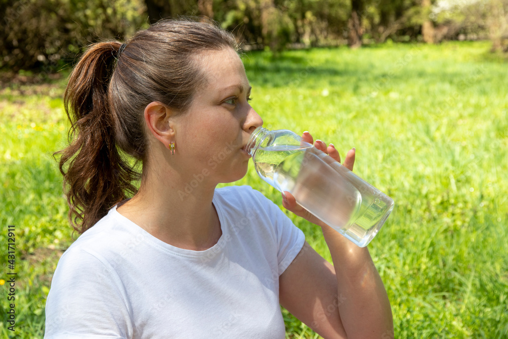 Young woman drinking water after fitness, health and sport concept. Woman drinking water from a bottle. Fitness women having a break after yoga exercise. Young woman drinking water after fitness, health and sport concept. Woman drinking water from a bottle. Fitness women having a break after yoga exercise.