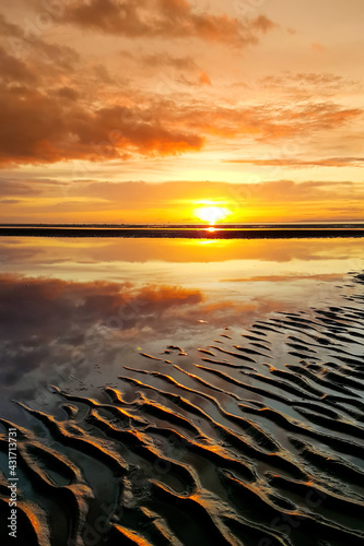 Beautiful sunset colors over the coastline of Allerdale district in Cumbria, UK. Sun setting over the shore of Allonby bay on autumn. photo