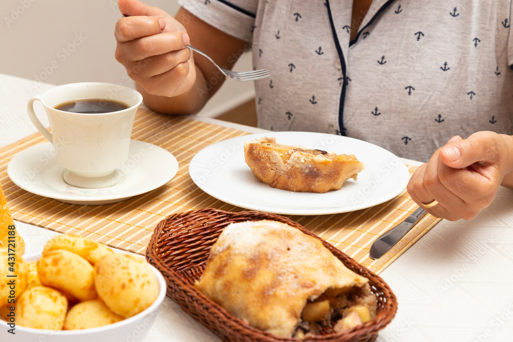 Woman making a meal, eating sweet strudel and coffee.