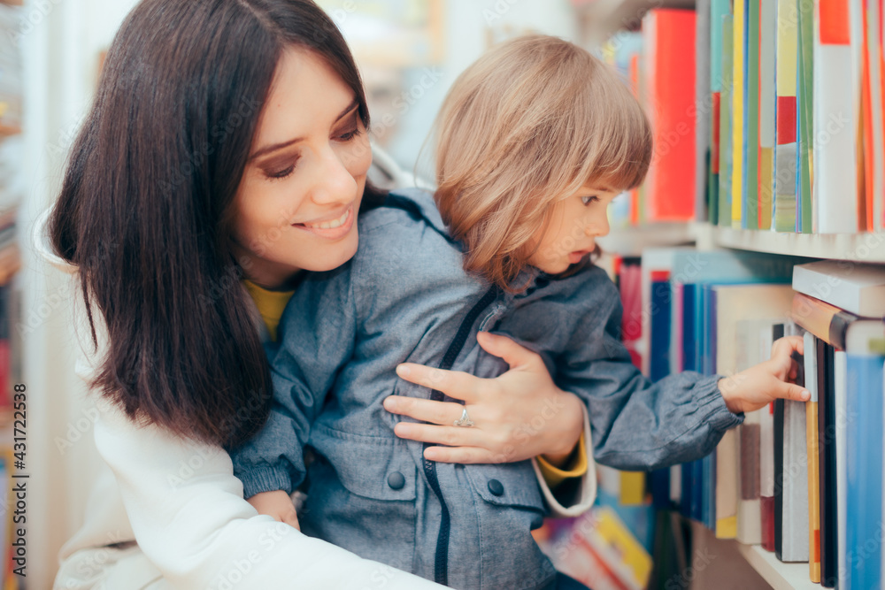 Happy Mother and Daughter Looking at a Book in a Library Happy Mother and Daughter Looking at a Book in a Library