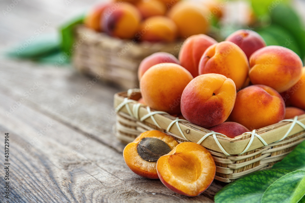 Delicious ripe apricots in a wooden bowl on the table close-up.Healthy fruits. Horizontal top view. Free space for your text.