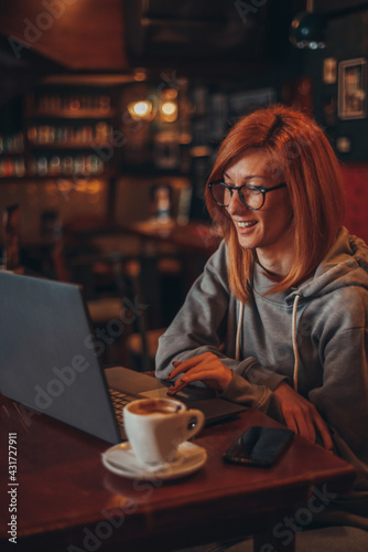 Woman working on her laptop w in a cafe