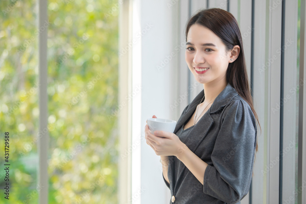 Woman working woman is looking drinking coffee in the morning office Woman working woman is looking drinking coffee in the morning office