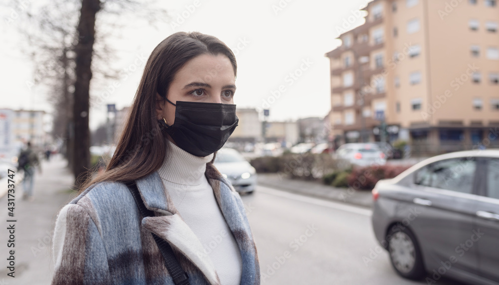 Woman with face mask walking down the street Woman with face mask walking down the street