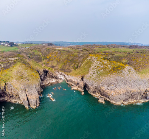 An aerial view from sea into an isolated rocky cove on the Pembrokeshire coast near to Tenby, South Wales in springtime