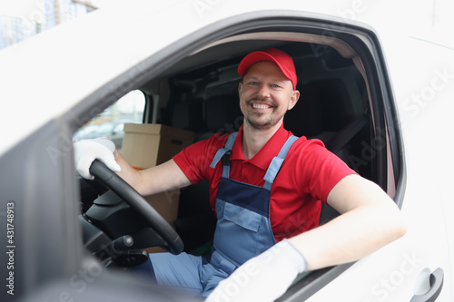 Smiling male courier driver driving car closeup