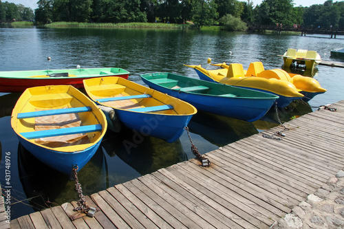 Bright multicolored boats and catamarans at the pier on a sunny summer day. The picture was taken at the Galvė lake in Lithuania.