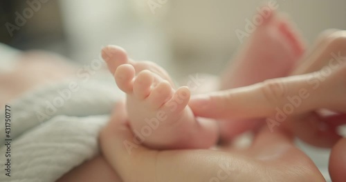 Tiny Newborn Baby's feet in mother hands. Mom and her Child. Happy Family concept.