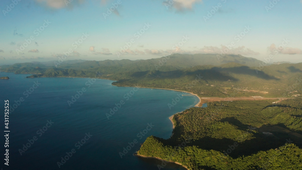 Aerial view coastline of tropical island and sea at sunrise. El nido, Palawan, Philippines. Seascape, island covered with forest in the morning. tropical landscape