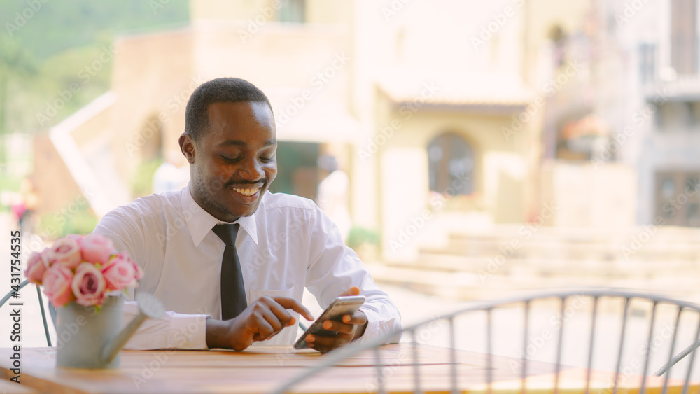 Handsome smiling african business man using smartphone in cafe restaurant