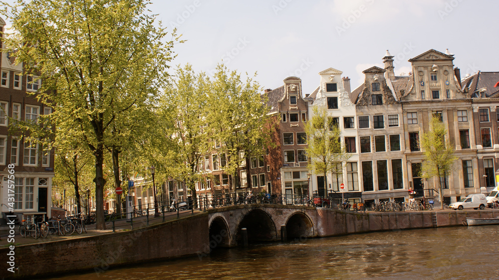 Amsterdam, Netherlands, April 2011: A cityscape of a charming side of the city with a three arch bridge in springtime.