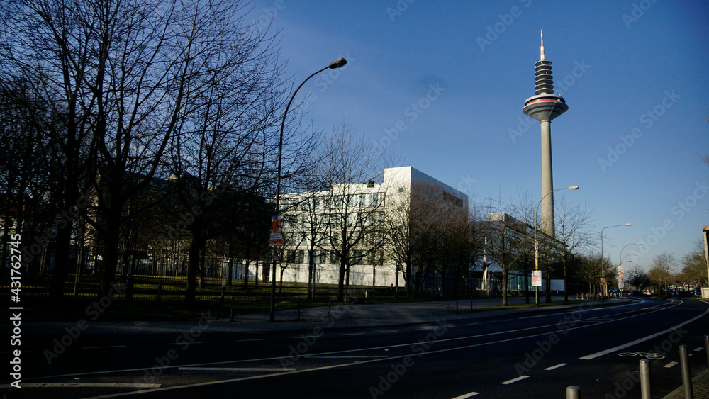 Naklejka premium Der Europaturm / frankfurter Spargel, Fernmeldeturm in Frankfurt am Main zwischen Baumen und Wohnhäusern vor blauem Himmel