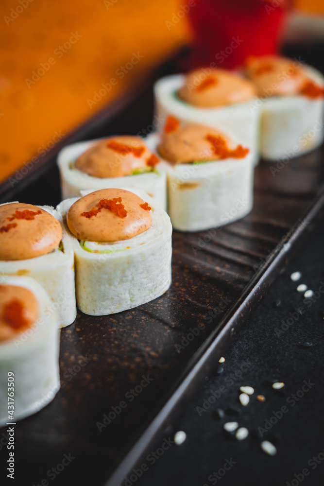 Rolls with salmon and eel on a black plate in a beautiful presentation Rolls with salmon and eel on a black plate in a beautiful presentation