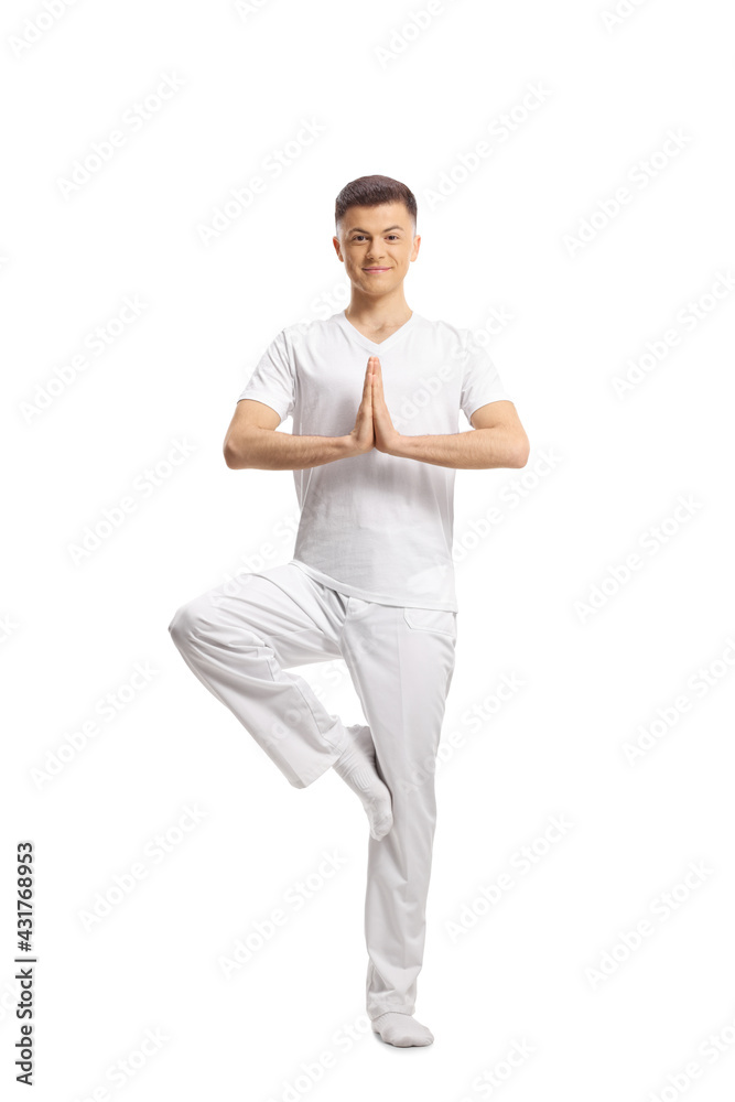 Full length portrait of a young man in white clothes standing in a yoga pose Full length portrait of a young man in white clothes standing in a yoga pose
