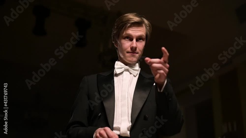 The young conductor makes an epic gesture in the direction of the musician and waves his wand. Slow motion
