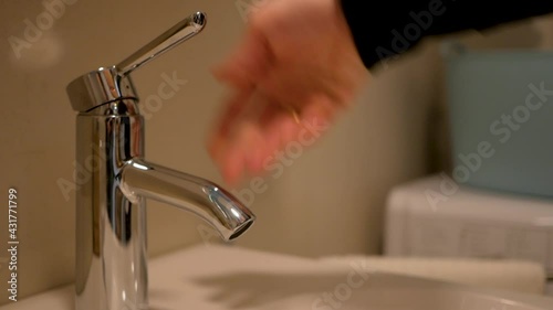 there is no water in the tap, it is broken. The girl turns the water tap, from which no water flows