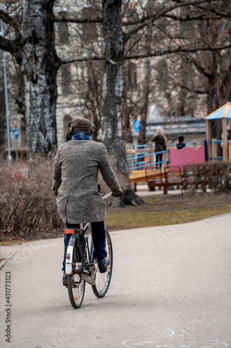 Man in winter clothes rides a bicycle through the city (324) © Maayan