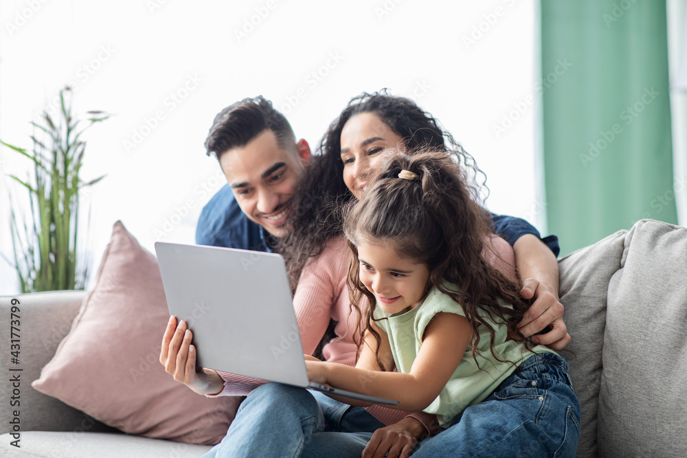 Happy Middle Eastern Family Of Three Spending Time With Laptop At Home