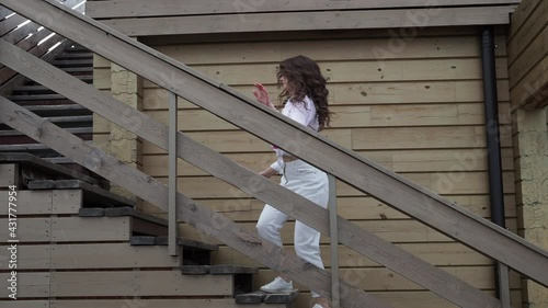 Beautiful young girl dancing on the street going down the stairs.