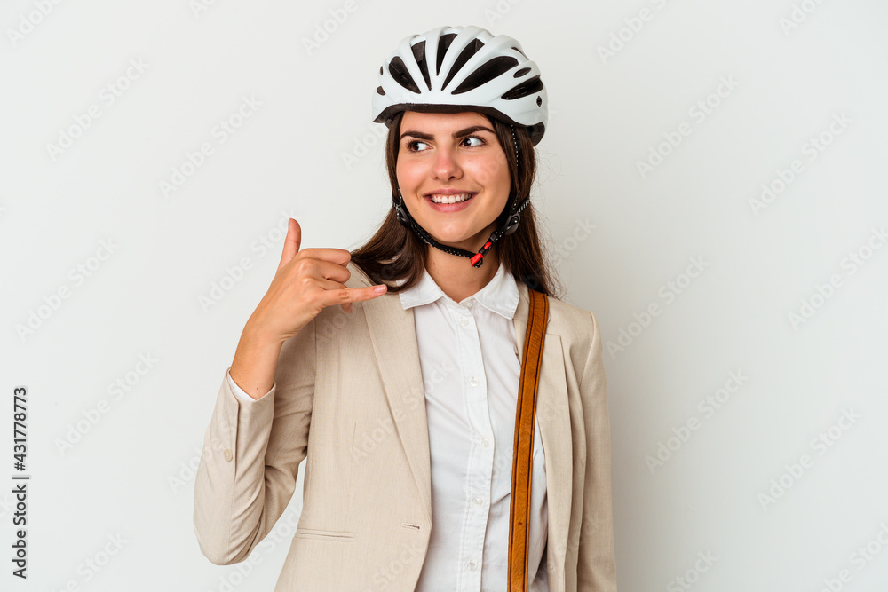 Young caucasian woman riding a bicycle to work isolated on white background showing a mobile phone call gesture with fingers. Young caucasian woman riding a bicycle to work isolated on white background showing a mobile phone call gesture with fingers.