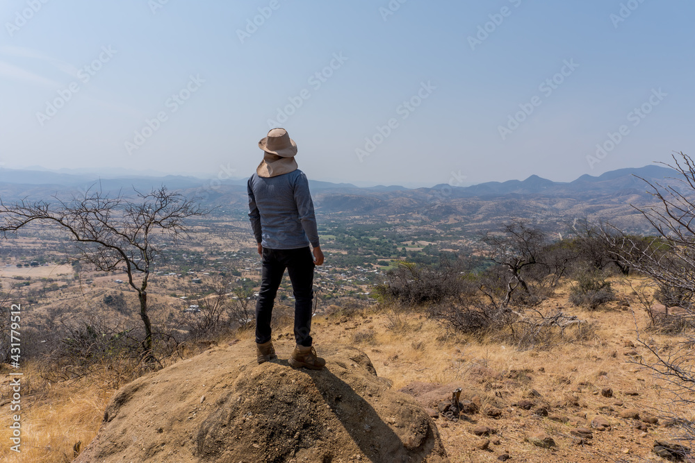 Traveler in a park with Lophocereus marginatus and bare trees in Mixteca Poblana, Puebla, Mexico Traveler in a park with Lophocereus marginatus and bare trees in Mixteca Poblana, Puebla, Mexico