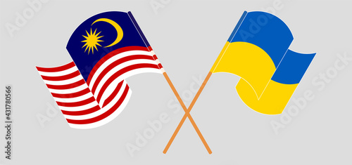 Crossed and waving flags of Malaysia and Ukraine