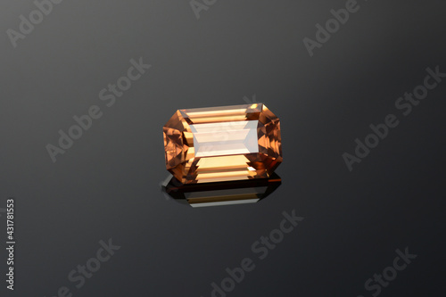 Canvastavla Natural mined yellowish brown cognac color emerald cut flawless transparent zircon loose gemstone setting for making jewelry on dark gray gradient background