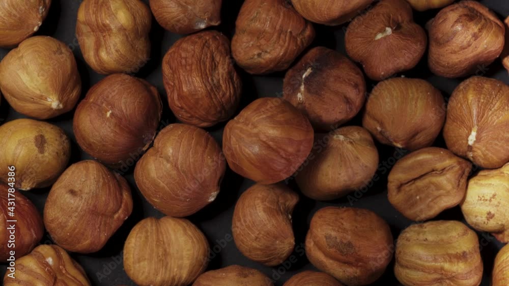 Peeled hazelnuts. Rotates on a black background. a handful of nuts. close-up, top view Peeled hazelnuts. Rotates on a black background. a handful of nuts. close-up, top view
