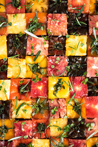 Farm Fresh Tomatoes with Fresh Herbs and Sea Salt. All Types of Tomatoes Diced in Squares. Abstract Background