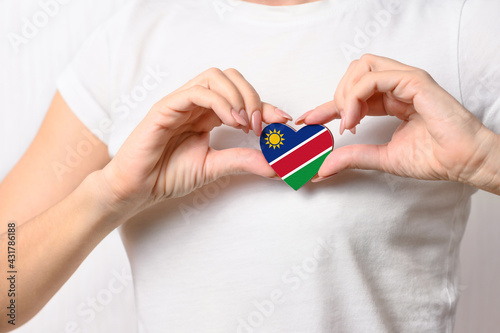 Flag of Namibia in the shape of a heart in the hands of a girl. Love Namibia. Respect for Namibians