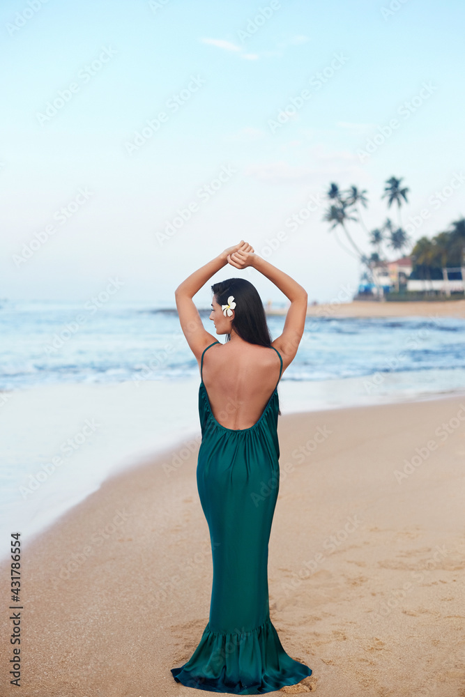 Portrait of beautiful young woman in dress on the beach. Pretty girl on tropical beach. Freedom concept, holiday, beach Portrait of beautiful young woman in dress on the beach. Pretty girl on tropical beach. Freedom concept, holiday, beach