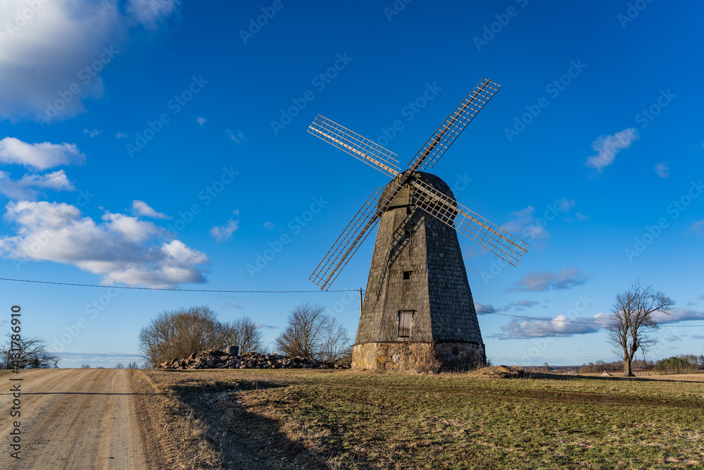 Old windmills at the edge of the rural road..