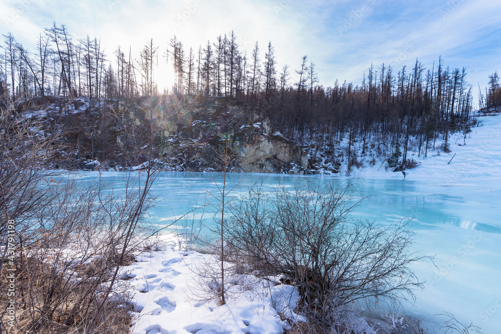 Turquoise ice in the frozen bed of the Irkut River in early spring. Republic of Buryatia, Russia, Siberia