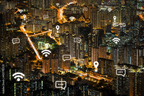 Map pin, WiFi and message icons on Hong Kong's cityscape at dusk. View of lit apartment buildings in Kowloon at night in Hongkong, China. Travel, wireless network connection, WiFi & messaging concept.