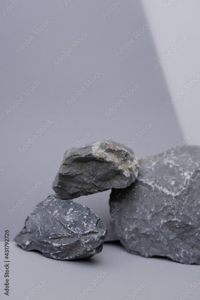 Naklejka premium Gray stones on a gray background. Monochrome background.