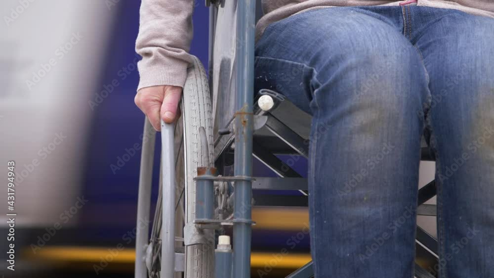 Wheelchair users at railway station as train passes Wheelchair users at railway station as train passes