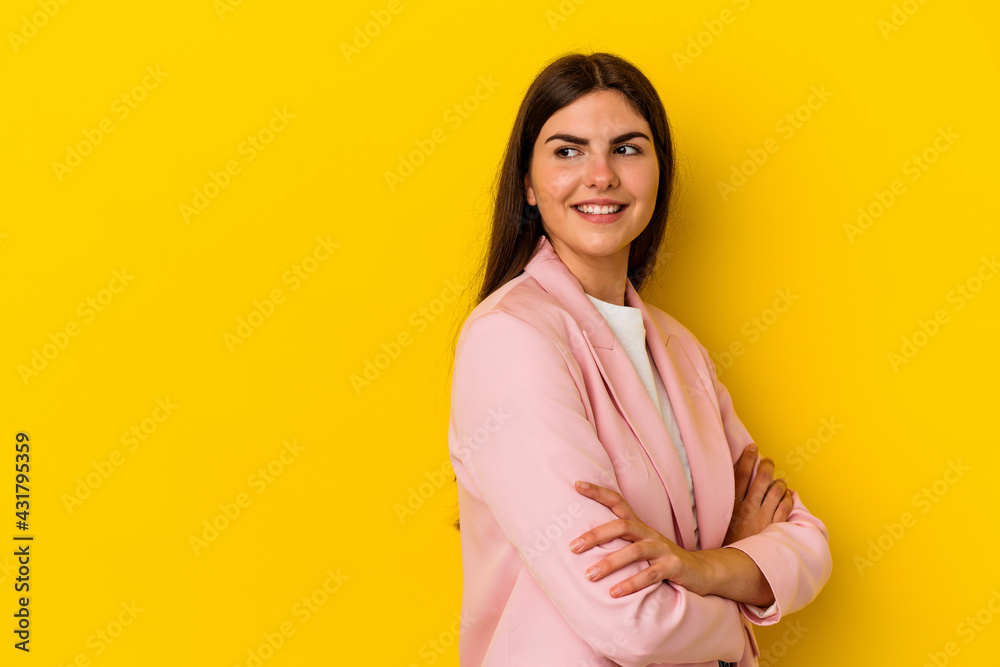 Obraz premium Young caucasian woman isolated on yellow background smiling confident with crossed arms.