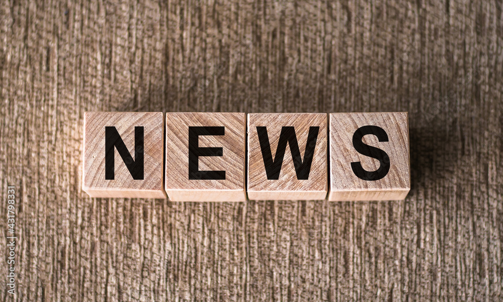 Fototapeta premium NEWS word written on wooden blocks on a brown background.