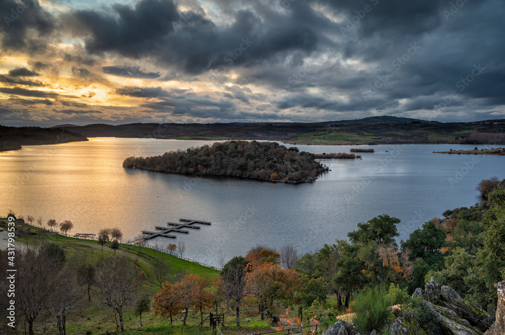 Obraz premium Wonderful sunset in Tras Os Montes, northern Portugal. Amazing landscape of Albufeira do Azibo. A huge lake with river beach and dock for pleasure boats. Postcard with panoramic view in the background