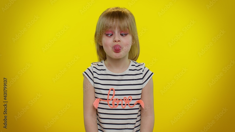 Funny cute teen child kid girl making playful silly facial expressions and grimacing, fooling around, showing tongue. Posing isolated on yellow studio background. Childhood lifestyle. Young children Funny cute teen child kid girl making playful silly facial expressions and grimacing, fooling around, showing tongue. Posing isolated on yellow studio background. Childhood lifestyle. Young children